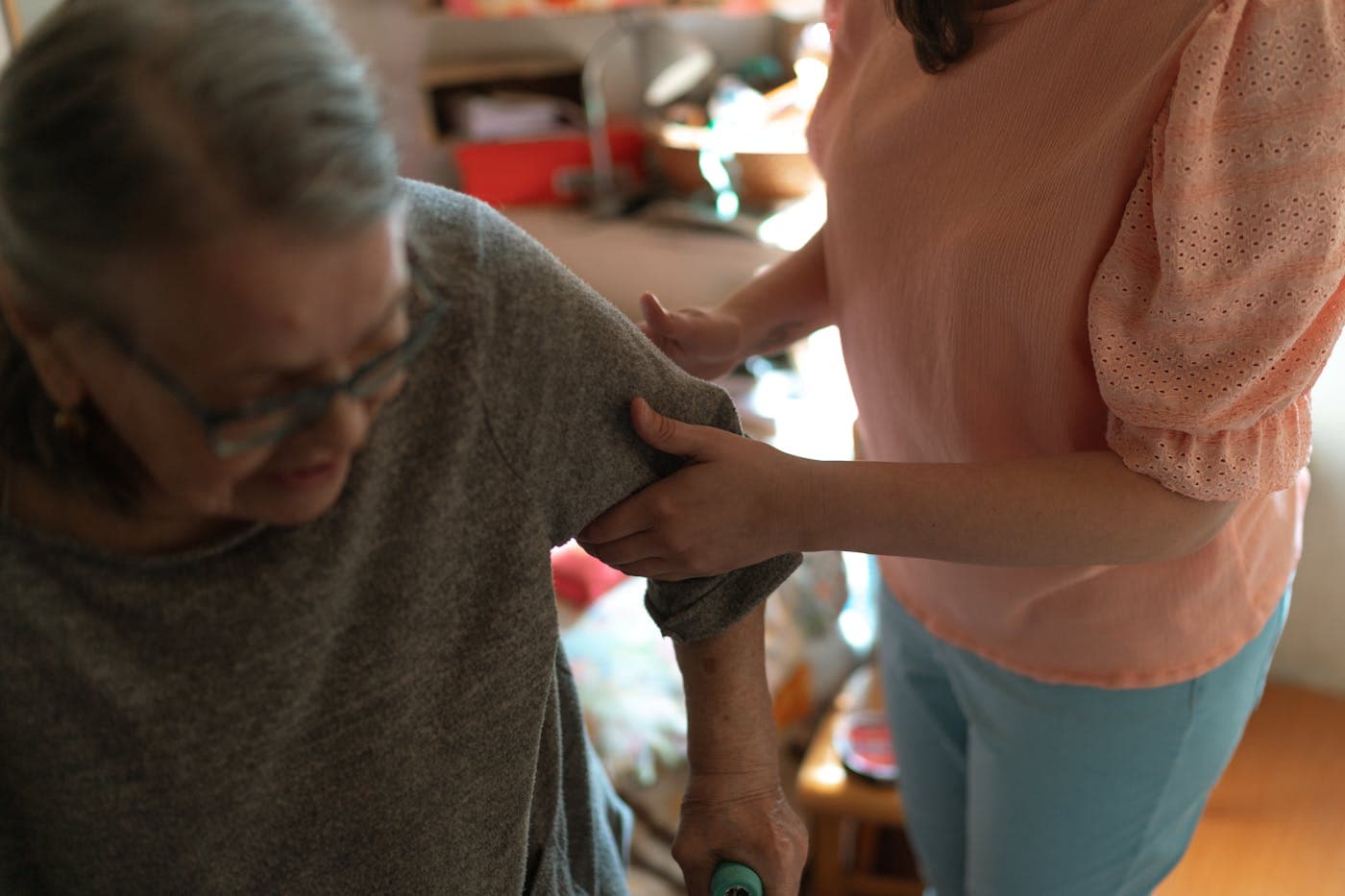 A caregiver offering steady support to an older adult at home