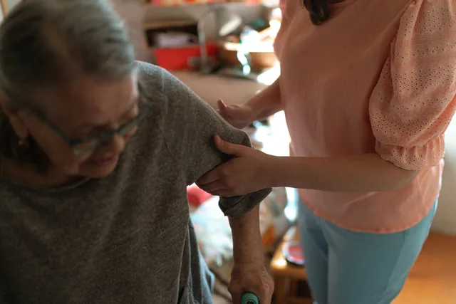 A caregiver offering steady support to an older adult at home
